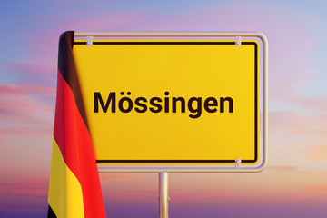 Mössingen. Gelbes Schild/Ortsschild. Flagge von Deutschland hängt darüber. Himmel mit Sonnenuntergang oder Sonnenaufgang