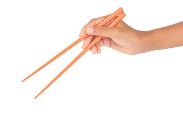  Women's hand holding orange plastic chopsticks isolated on white background.