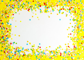 Confetti scattered in different colors on the white background. Festive confetti. The decor for the party.