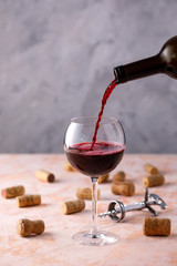 Red wine is poured into a glass. The concept of winemaking. Place under your text.