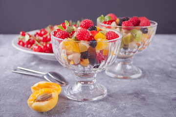 salad with fresh fruits and berries on a bowls on the concreate background