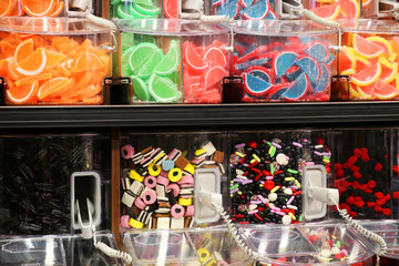 Bright colors candy background. Assorted bulks of colorful candies in plastic boxes at the candy shop close up.