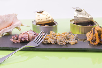 Close-up of a fresh sliced poton, cockles served on a black stone tablet and a fork