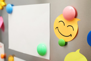 Sheets of paper and magnets on refrigerator door, closeup. Space for text