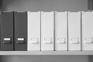 Folders with documents on shelf in archive