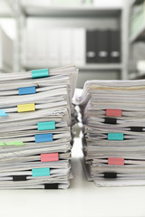 Stacks of documents with paper clips on office desk