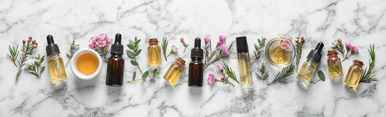 Flat lay composition with bottles of natural tea tree oil and space for text on white marble background - obrazy, fototapety, plakaty