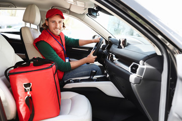 Male courier with thermo bag in car. Food delivery service