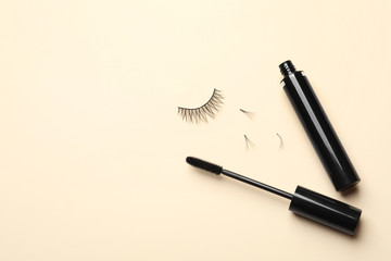 False eyelashes and mascara on light background, flat lay. Space for text