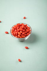 Frische Goji-Beeren Superfood in Glas Schale auf Mint Grün Pastell Hintergrund
