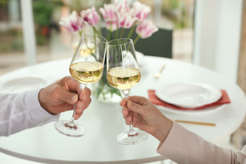 Obraz na płótnie Canvas People with glasses of wine on blurred background, closeup
