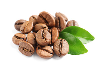Fototapeta premium Roasted coffee beans and fresh green leaves on white background