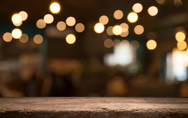 Empty wood table top on blur light gold bokeh of cafe restaurant in dark background