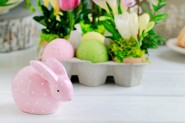 Dotted pink ceramic rabbit and floral decoration in the background.