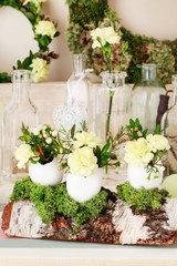 Easter decoration with egg shell, carnation flower, buxus, chamelaucium and moss