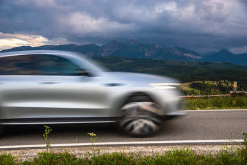 a modern SUV riding a mountain road leading through a pass