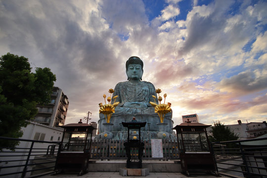Wide angle view of  the Great Buddha,Hyogo Daibutsu at  Nofukuji Temple with sky,clouds and light evening sun, Kobe ,Japan