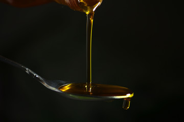 Oil pouring to the spoon from the bottle