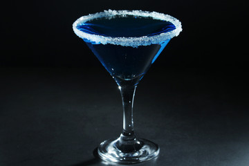 A glass with blue martini cocktail	