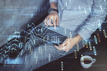 Forex graph with businessman working on computer in office on background. Concept of analysis. Double exposure.