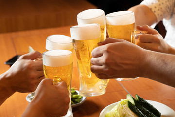 居酒屋でビールで乾杯をするイメージ