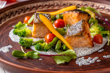 Baked Salmon on Chia Sauce with broccoli, carrots, cherry tomatoes and green beans, horizontal photo, close-up