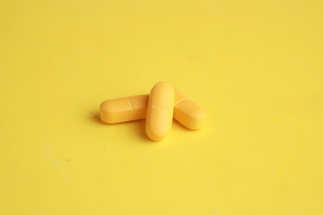orange elongated pharmacy pills on colored background