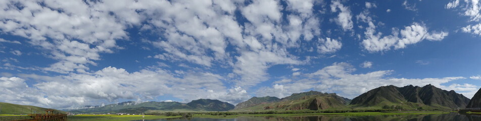 Obraz na płótnie Canvas Beautiful landscape in western China Mountains clouds blue sky and mirroring christal clear lake