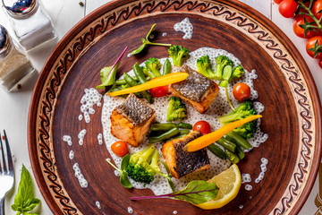 Baked Salmon on Chia Sauce with broccoli, carrots, cherry tomatoes and green beans, horizontal photo, top view