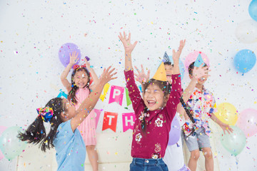 Happy Asian Girl Enjoy Throwing Colorful Confetti with Friends in Birthday Party