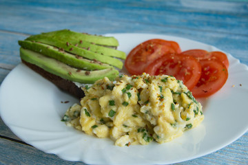 Sandwich with avocado and cheese, scramble and tomatoes