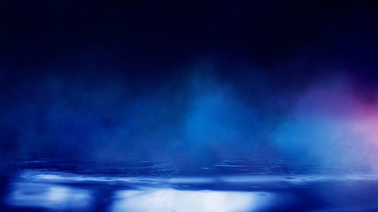 Wet asphalt, reflection of neon lights, a searchlight, smoke. Abstract light in a dark empty street with smoke, smog. Dark background scene of empty street, night view, night city.