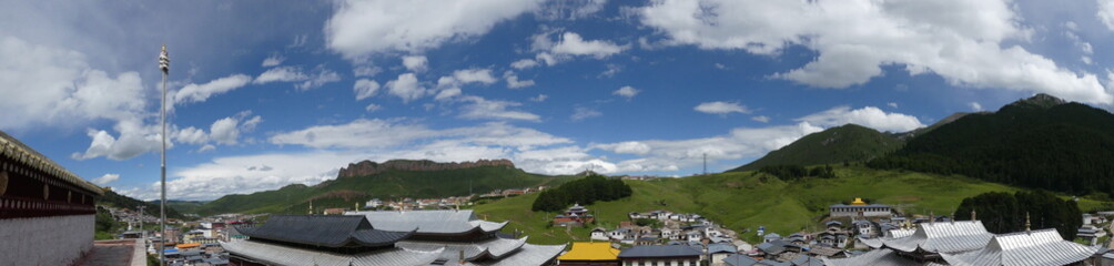 Obraz premium Übersicht über das tibetanische Kloster in Langmusi - Tempelanlage mit Bergen im HIntergrund