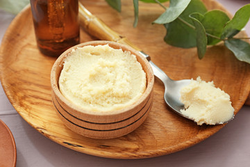 Bowl and spoon with shea butter on table