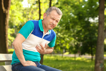 Fototapeta premium Mature man suffering from heart attack outdoors