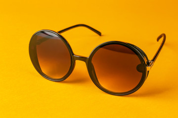 Modern sunglasses on color background