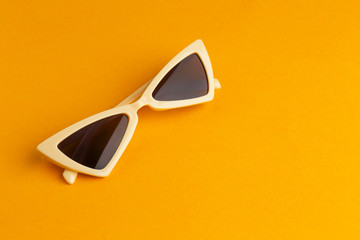 Modern sunglasses on color background