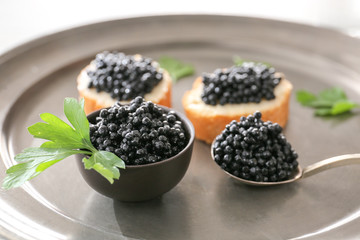 Delicious caviar and bread on tray, closeup