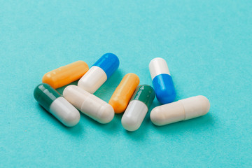 colour tablets and pills on blue background .