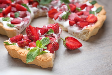 Tasty strawberry cake on table