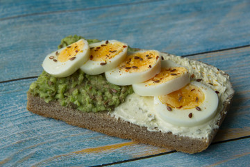 Sandwich with avocado paste, cottage cheese and sliced boiled egg