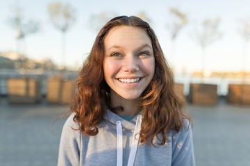 Outdoor portrait of beautiful smiling teenager girl 14, 15 years old