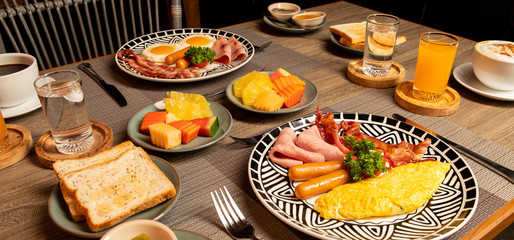 Breakfast on the table is bacon, fried egg, coffee, tea, bread.