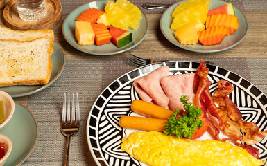 Breakfast on the table is bacon, fried egg, coffee, tea, bread.