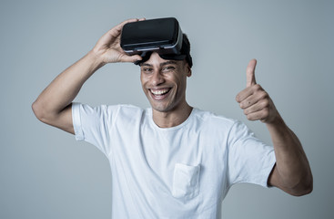 Portrait of cheerful young man wearing Virtual Reality goggles for first time smiling at camera