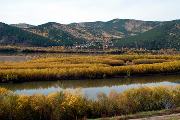 Between Ulan Ude and  Ust-Barguzin Russia, autumn view of river with village in distance