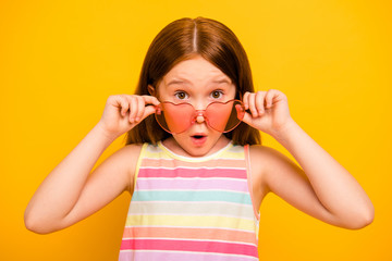 Close up photo of astonished girl touching her specs wearing singlet isolated over yellow background