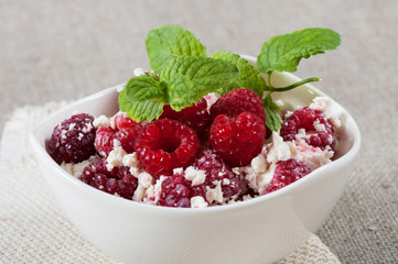 Sweet curd with raspberries, decorated with a sprig of mint.