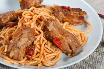Pasta spaghetti in tomato sauce and rib meat.