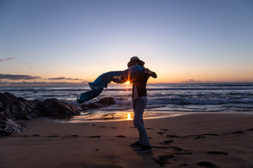 Silhouette of young girl with hat, at sunset on Cotillo beach, Fuerteventura, Canary Islands, Spain.